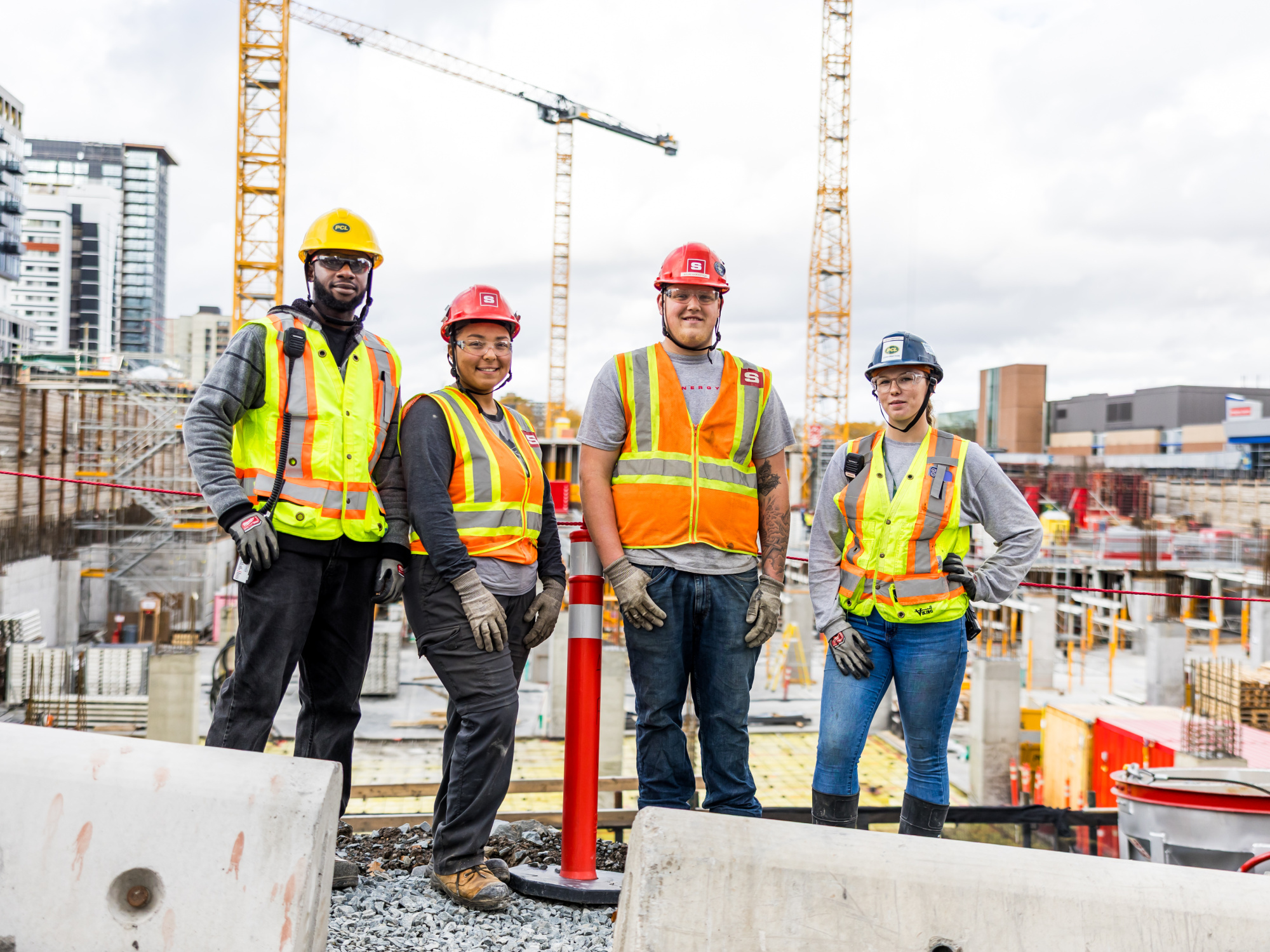 A group of apprentices poses in front of a job site.